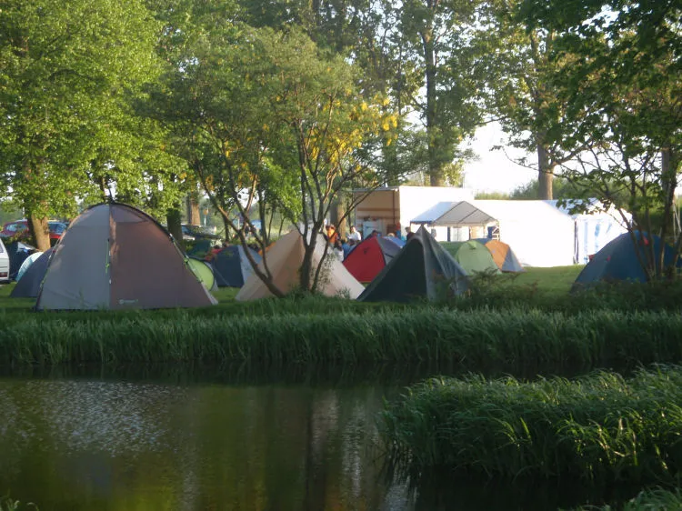 Vol kampeerveld met tenten aan de waterkant