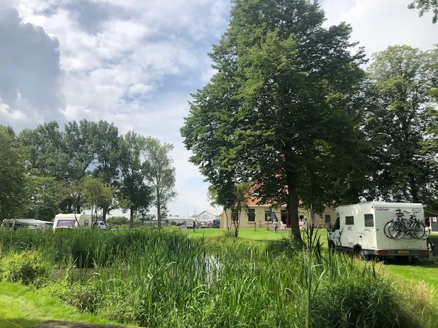 Kampeerveld met de boerderij op de achtergrond